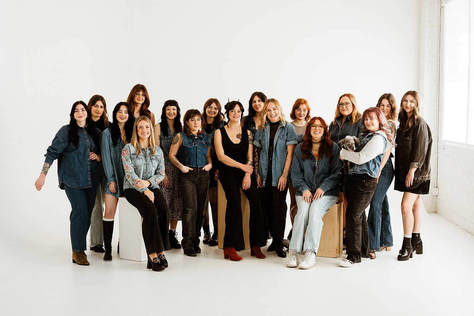 Group of women posing against a white backdrop in casual attire, smiling and relaxed.